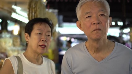 Asian elderly couple shopping at local wet market
