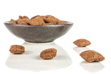 Lot of whole crispy brown cereal pillow in dark ceramic bowl isolated on white background