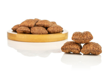 Lot of whole crispy brown cereal pillow on bamboo coaster isolated on white background