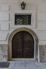 Fototapeta na wymiar brown wooden Elegant Double enterance door. Facade of baroque white building with stone panels