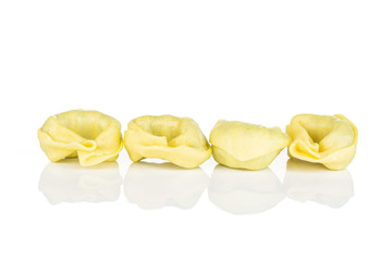 Group of four whole fresh yellow spinach filled tortelloni isolated on white background