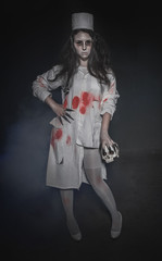 Terrible nurse woman and skull. Halloween horror scene