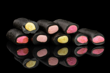 Group of eight whole sweet black liquorice candy isolated on black glass