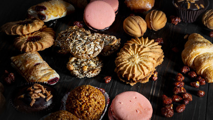Cookies, muffins, croissants, pasta baking sweets sprout style on a wooden table. A delicious set for coffee or tea. The idea of a Christmas fair.