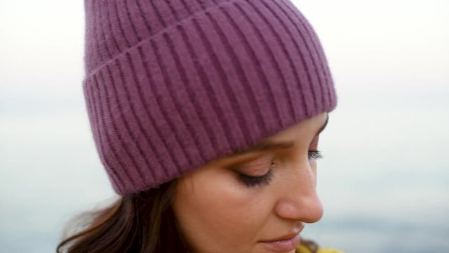 Closeup of Young pretty woman in mangenta hat on the background of sea