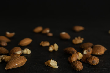Lot of whole brown almond nut heap isolated on grey stone