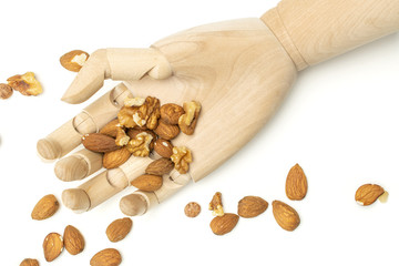 Lot of whole brown almond nut with wooden arm flatlay on white background