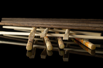 Lot of whole arranged asian brown chopsticks isolated on black glass