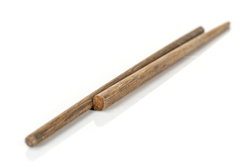Group of two whole dark asian brown chopsticks isolated on white background