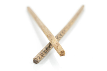 Group of two whole front focus asian brown chopsticks isolated on white background