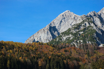 Autumn landscape in alps mountains under blue sky