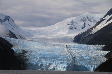 lodowiec schodzący do morza, z ośnieżonymi górami w tle antarktyda