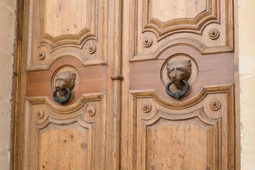 Valletta, Malta, August 2019. Beautiful wooden door of an old house with handles in the form of a lion`s head.