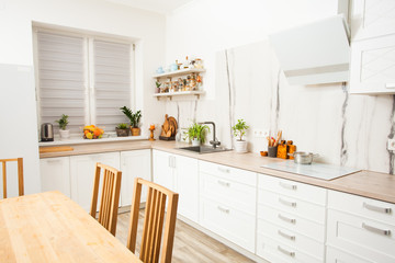 Sunny and bright kitchen with white marble wall.
