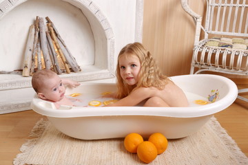 2 sisters bathe in a milk bath with oranges