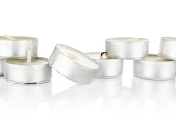 Lot of whole light waxy white tea candle stack isolated on white background