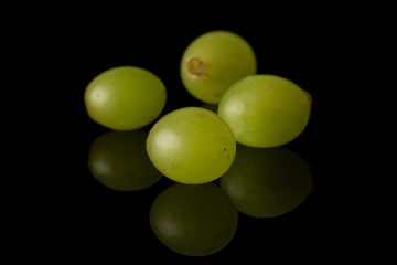 Group of four whole fresh green grape isolated on black glass