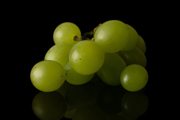 Lot of whole fresh green grape front focus isolated on black glass