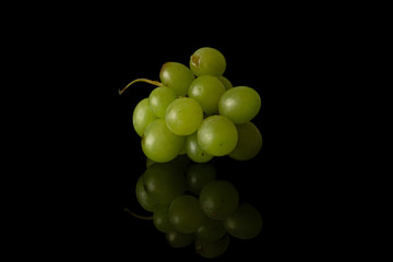 Lot of whole fresh green grape pile isolated on black glass