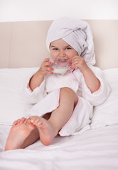 Pretty girl in a bathrobe on the bed