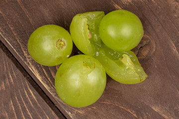 Lot of whole fresh green grape flatlay on brown wood