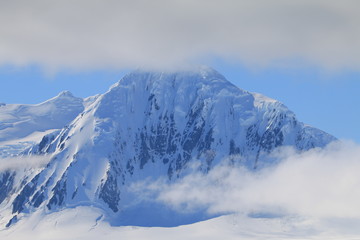 Fototapeta na wymiar ośnieżona góra ze szczytem w chmurach