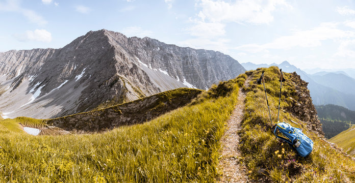 Backpack and walking sticks in mountainscape