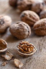 Couple of walnuts on the wooden background.