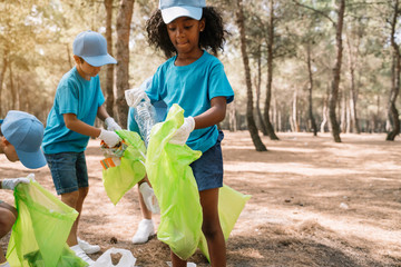 Group of volunteering children collecting garbage in a park
