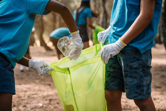 Close-up of volunteering children collecting garbage in a park