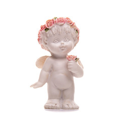 Fototapeta premium Statuette of an angel with wings, a flower in his hand and a wreath of pink flowers. Isolated on white background.
