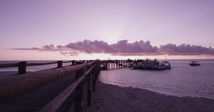 Colorful sunset over pier on Heron Island, wide