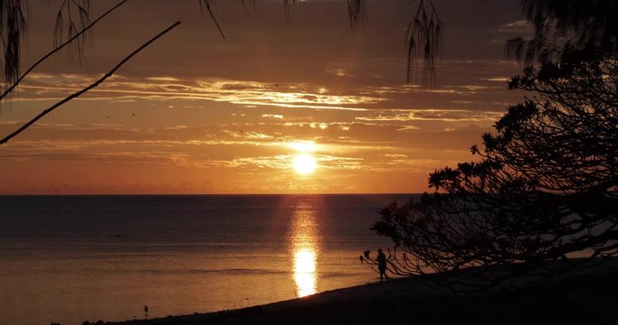 Wide, person walks on Heron Island at sunset