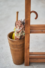 Two folded umbrellas in a wooden basket