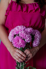 Woman holding a bouquet of pink chrysanthemums