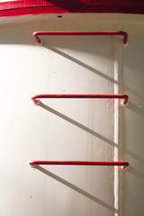 Red metal spar-ladder on a white wall