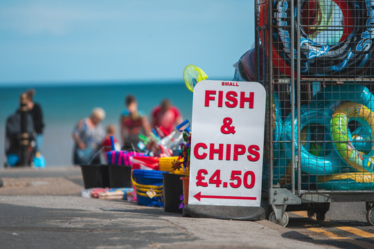 Sign That Says Small Fish And Chips For £4.50 For Sale At A Beach In The UK During Summer