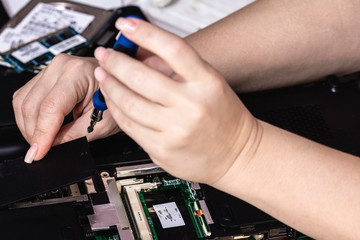 Woman engineer remove the cover of laptop using tool