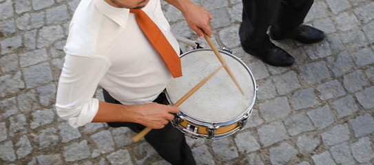 Homem a tocar tarola numa orquestra sinfónica de rua