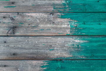 Wooden background texture blue paint partly covering planks.