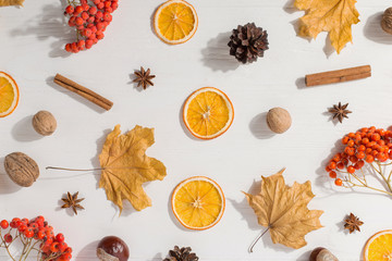 Dry yellow leaves, spices, chestnuts, berries, cones and oranges on the table. Autumn mood, copy space, morning light.