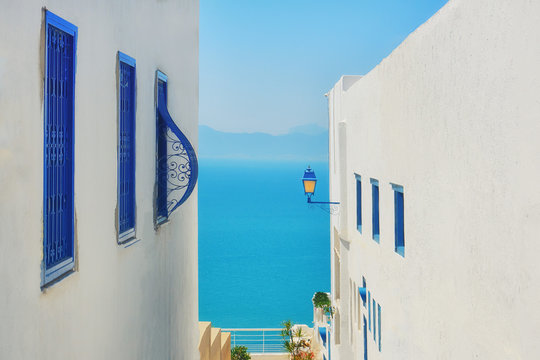 Sea and mountain views between two houses with blue windows, Sidi Bou Said, Tunisia