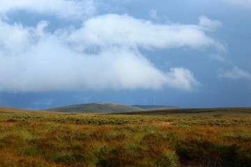 Sun shines above the clouds in a cloudy day in Ireland