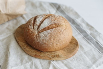 Loaf of bread on a board on a white tablecloth