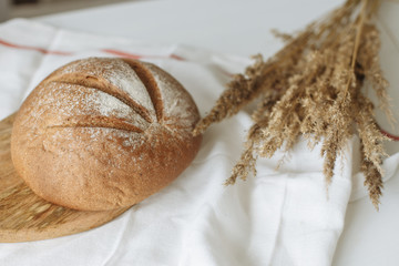 Loaf of bread on a board on a white tablecloth