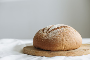 Loaf of bread on a board on a white tablecloth