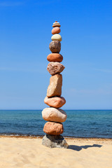 Fototapeta na wymiar Rock zen pyramid of colorful pebbles on a beach. Concept of balance, harmony and meditation.