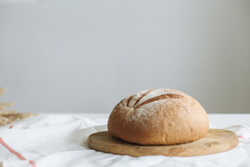 Loaf of bread on a board on a white tablecloth