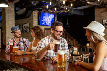 Two couple sitting in beer house and having fun