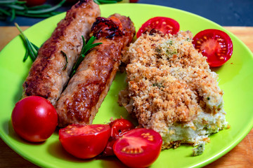 Grilled sausages with cherry tomatoes on a plate. Selective focus. Top view.